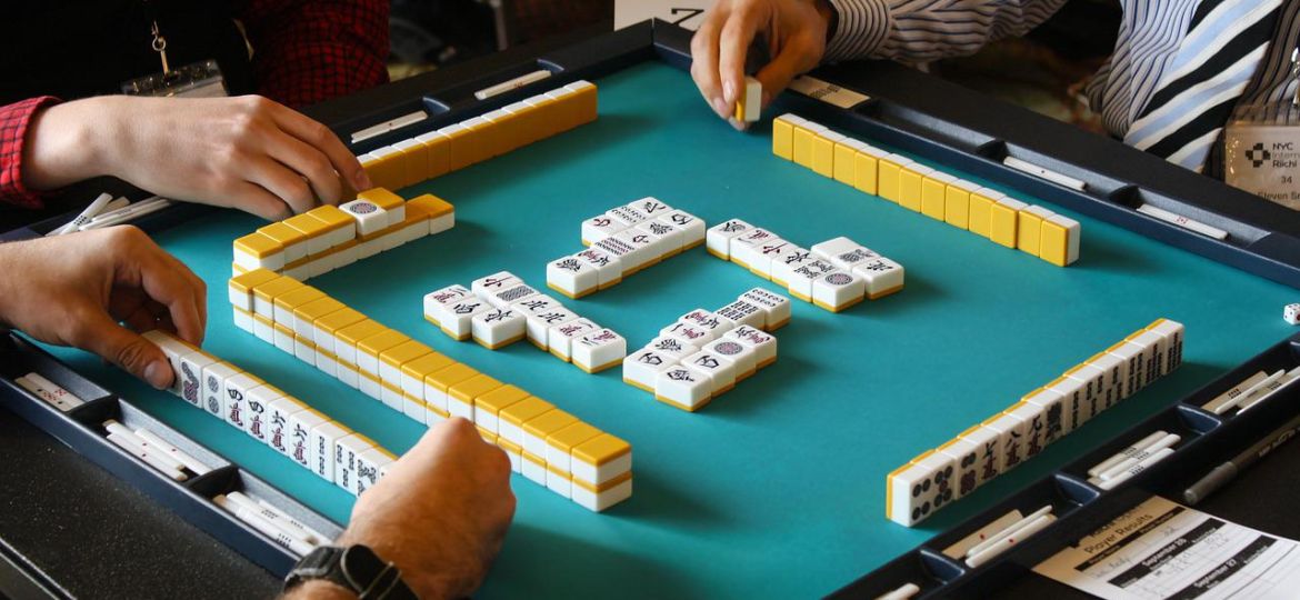 People playing mahjong around table