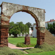 The courtyard of Mission San Luis Rey de Francia, with the first Peruvian Pepper Tree (Schinus molle) planted in California in 1830, visible behind the arch