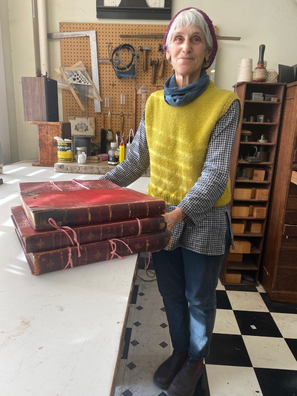 Judith Ivry with a stack of giant red bound books