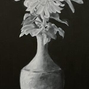 A stony white vase contains a small bouquet of brilliant white flowers that stand in stark contrast to the pitch blackness of the background.