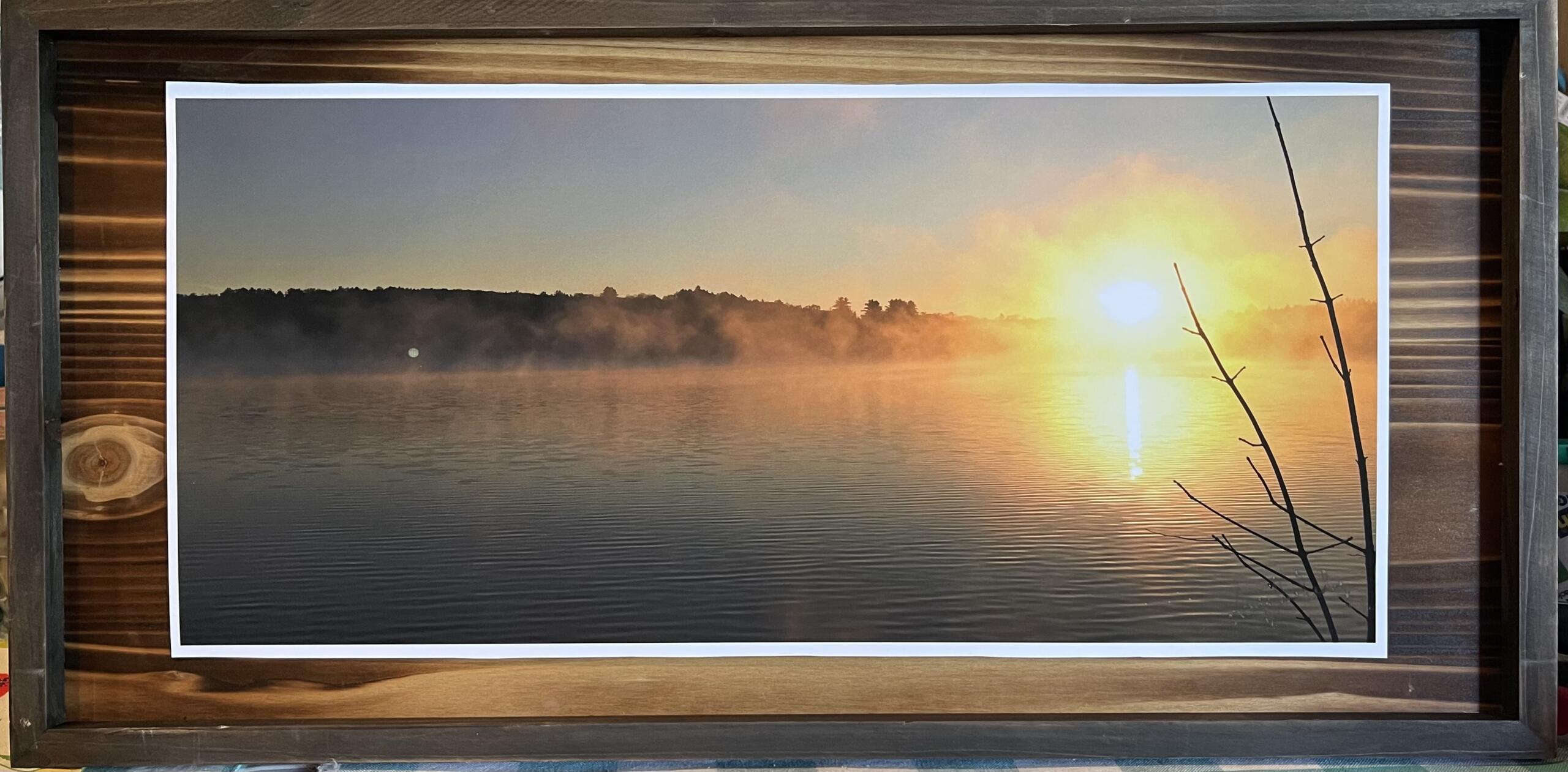 "Swan lake sundown" in a dark wood frame with defined grain.