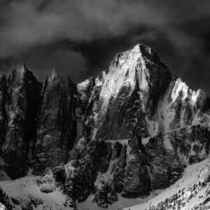 Black and white: a snowy mountain range on a cloudy day.